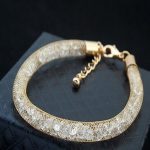 Zlatý cylindrický náramok zdobený kryštálmi Swarovski